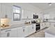 Bright, white kitchen featuring granite countertops, stainless steel appliances, and white cabinets at 15718 W Polk St, Goodyear, AZ 85338
