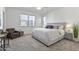 Bright, white main bedroom with a large bed, chair and windows at 15718 W Polk St, Goodyear, AZ 85338
