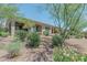 Landscaped backyard with gravel and flowering plants surrounding a home with a covered patio and shade trees at 16417 W Piccadilly Rd, Goodyear, AZ 85395