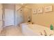 Luxurious bathroom featuring a soaking tub and a glass-enclosed shower with tiled walls and natural light at 16417 W Piccadilly Rd, Goodyear, AZ 85395