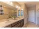 Stylish bathroom with dual sinks, large mirrors, and a glass-enclosed shower featuring decorative tile at 16417 W Piccadilly Rd, Goodyear, AZ 85395
