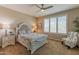 Charming bedroom with a ceiling fan, comfortable bed, and abundant natural light from plantation shutters at 16417 W Piccadilly Rd, Goodyear, AZ 85395