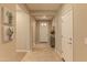 Inviting hallway with neutral tones, tiled flooring, and a view of the front door, enhancing the home's warmth at 16417 W Piccadilly Rd, Goodyear, AZ 85395
