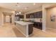 Modern kitchen with dark cabinets, stainless steel appliances, a large island, and sleek countertops at 16417 W Piccadilly Rd, Goodyear, AZ 85395