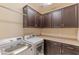 Spacious laundry room with upper cabinets, counter space, and modern washer and dryer appliances at 16417 W Piccadilly Rd, Goodyear, AZ 85395