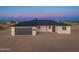 Exterior view of a charming single-story home with a gray garage door and desert landscape at 16627 N Slate Ln, Maricopa, AZ 85139
