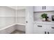 Bright walk-in pantry with lots of shelving and luxury vinyl plank flooring at 16627 N Slate Ln, Maricopa, AZ 85139