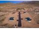 Aerial view of new homes with desert landscaping, roads and mountain views at 16630 N Slate Ln, Maricopa, AZ 85139