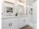 Bright bathroom featuring double sinks, gold hardware, and a glass shower with white tile at 16630 N Slate Ln, Maricopa, AZ 85139