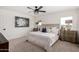 Bright bedroom with a ceiling fan, neutral carpet and decor, and a beautiful view from the window at 16630 N Slate Ln, Maricopa, AZ 85139