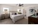 Bright bedroom with a ceiling fan, neutral carpet and decor, and a desert view from the window at 16630 N Slate Ln, Maricopa, AZ 85139