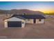 Beautiful single-story home with a dark gray garage door and mountain views at 16630 N Slate Ln, Maricopa, AZ 85139