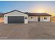 Charming home with a modern garage door, desert landscaping, and a welcoming front entrance at 16630 N Slate Ln, Maricopa, AZ 85139