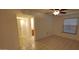 Bedroom with neutral tile flooring, white walls, access to bathroom and a ceiling fan at 17056 N 107Th Ave, Sun City, AZ 85373