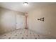 Empty bedroom with tile flooring, a TV mount, and an open closet at 1811 W Roma Ave, Phoenix, AZ 85015
