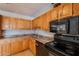 View of kitchen showcasing black microwave, range, dishwasher, and wooden cabinets with lots of potential at 1811 W Roma Ave, Phoenix, AZ 85015