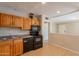 Kitchen features wood cabinets, black appliances and tile flooring at 1811 W Roma Ave, Phoenix, AZ 85015