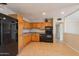 Functional kitchen with wood cabinets, black appliances, and tile flooring at 1811 W Roma Ave, Phoenix, AZ 85015