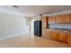 View of kitchen showcasing black refrigerator, tile flooring, and wooden cabinets with lots of potential at 1811 W Roma Ave, Phoenix, AZ 85015