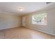 Open living room features tile flooring, neutral paint, and natural light from the window at 1811 W Roma Ave, Phoenix, AZ 85015