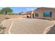 Spacious backyard with gravel landscaping, a covered patio, and a block wall fence for privacy at 1819 W Deer Creek Rd, Phoenix, AZ 85045