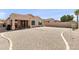 A gravel backyard with a covered patio, privacy wall and access to the home through sliding glass doors at 1819 W Deer Creek Rd, Phoenix, AZ 85045