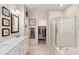 Elegant bathroom with marble countertops, double sinks, a glass-enclosed shower, and a walk-in closet at 1819 W Deer Creek Rd, Phoenix, AZ 85045