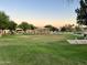 Well-maintained community park with a vast green lawn, ramada, walking path, and mature trees at 1819 W Deer Creek Rd, Phoenix, AZ 85045