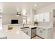 Bright kitchen featuring white cabinets, stainless steel appliances, and stylish countertops overlooking living area at 1819 W Deer Creek Rd, Phoenix, AZ 85045