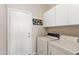 Functional laundry room with a washer, dryer, and storage cabinets for seamless organization at 1819 W Deer Creek Rd, Phoenix, AZ 85045