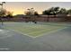 Well-maintained tennis courts at sunset with mountain views, surrounded by mature trees at 1819 W Deer Creek Rd, Phoenix, AZ 85045
