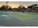 Well-maintained tennis courts at sunset with mountain views, surrounded by mature trees at 1819 W Deer Creek Rd, Phoenix, AZ 85045