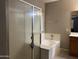Bright bathroom featuring tub with shower and glass door enclosure and neutral earthy decor at 20931 E Desert Hills Blvd, Queen Creek, AZ 85142