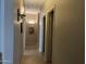 Hallway with arch and neutral-toned tile floors, decorative sconce lighting and access to living spaces at 20931 E Desert Hills Blvd, Queen Creek, AZ 85142