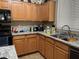A functional kitchen featuring light wood cabinets, granite countertops, and black appliances at 20931 E Desert Hills Blvd, Queen Creek, AZ 85142