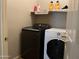 Functional laundry room featuring modern Samsung washer and Whirlpool dryer with convenient storage shelving at 20931 E Desert Hills Blvd, Queen Creek, AZ 85142