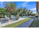 Inviting backyard with a sparkling pool, lush greenery, and comfortable seating area for outdoor relaxation at 2219 E Galileo Dr, Gilbert, AZ 85298