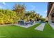 Beautiful backyard with a sparkling pool, lush lawn, outdoor seating, and manicured landscaping at 2219 E Galileo Dr, Gilbert, AZ 85298