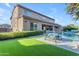 Beautiful backyard features synthetic grass, a gorgeous pool, patio furniture, and luscious foliage at 2219 E Galileo Dr, Gilbert, AZ 85298