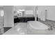 Bathroom featuring a large soaking tub, tile backsplash, and decorative mirrors above dual sinks at 2219 E Galileo Dr, Gilbert, AZ 85298
