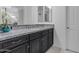 Bathroom vanity featuring dark cabinets, granite countertops, and decorative mirrors at 2219 E Galileo Dr, Gilbert, AZ 85298