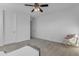 Cozy bedroom featuring neutral walls, carpeting, ceiling fan, and a comfortable chair at 2219 E Galileo Dr, Gilbert, AZ 85298