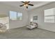 Bright bedroom featuring neutral walls, carpeted floor, ceiling fan and natural light from a large window at 2219 E Galileo Dr, Gilbert, AZ 85298
