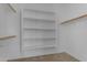 Bright, empty walk-in closet features built-in shelving and carpeting at 2219 E Galileo Dr, Gilbert, AZ 85298