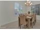 Bright dining room with tile floors, large windows, and a modern chandelier with seating for six at 2219 E Galileo Dr, Gilbert, AZ 85298
