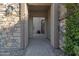Inviting stone-accented entryway features a decorative door and paver walkway, creating a charming welcome to the home at 2219 E Galileo Dr, Gilbert, AZ 85298