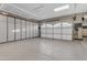 Large garage featuring epoxy floors, built-in cabinets, storage, and insulated garage doors at 2219 E Galileo Dr, Gilbert, AZ 85298