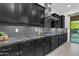 Kitchen featuring custom black cabinetry, granite countertops and mosaic tile backsplash at 2219 E Galileo Dr, Gilbert, AZ 85298
