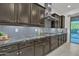 Elegant kitchen features granite counters, tiled backsplash, stainless steel appliances, and ample cabinetry at 2219 E Galileo Dr, Gilbert, AZ 85298