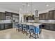 Gourmet kitchen featuring a large island with seating, stainless steel appliances, and stylish pendant lighting at 2219 E Galileo Dr, Gilbert, AZ 85298